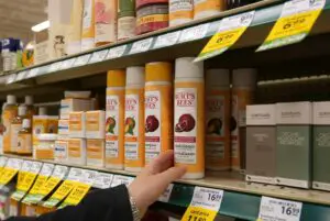 Person showing uncle Burt's Bees shampoo on a shelf in a shop